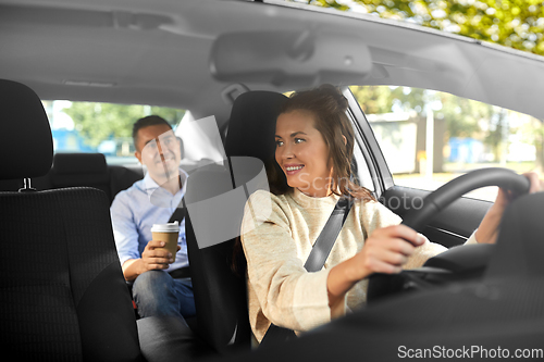 Image of female driver driving car with male passenger