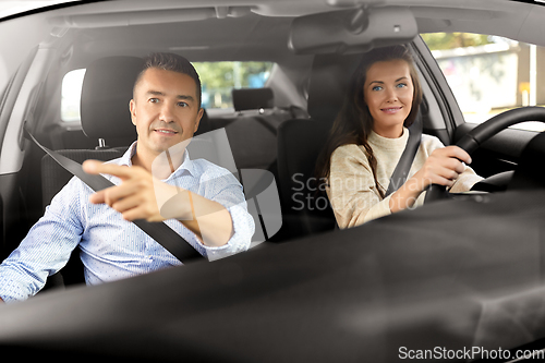 Image of car driving school instructor teaching woman