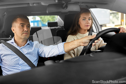 Image of car driving school instructor teaching woman