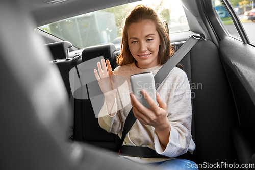 Image of happy woman in car having video call on smartphone