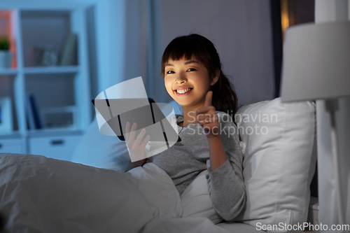 Image of asian woman with tablet pc in bed at home at night