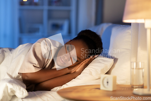 Image of sleepless african woman lying in bed at night