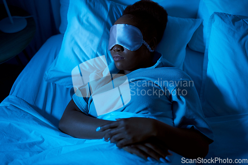 Image of african woman sleeping in bed at home at night