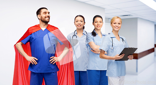 Image of male doctor in superhero cape and nurses at clinic