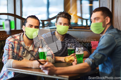 Image of friends take selfie and drinking green beer at bar