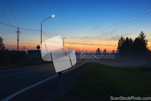 Image of Night Country Highway Illuminated by Street Lamps at Sunset