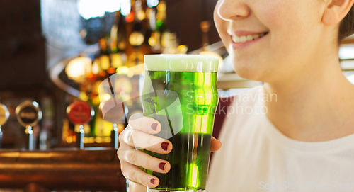 Image of close up of woman with green beer in glass