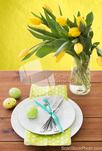 Image of easter egg, plates, cutlery and tulip flowers