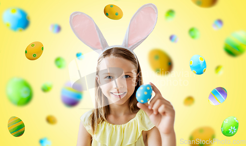 Image of happy girl with colored easter egg on yellow