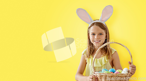 Image of happy girl with colored easter eggs over yellow