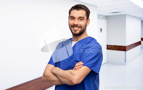 Image of happy smiling doctor or male nurse in blue uniform