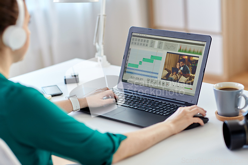 Image of woman with video editor program on laptop at home