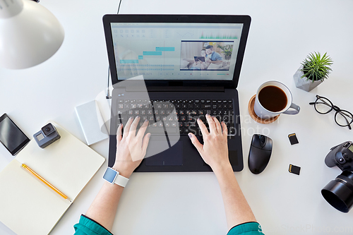 Image of woman with video editor program on laptop at home