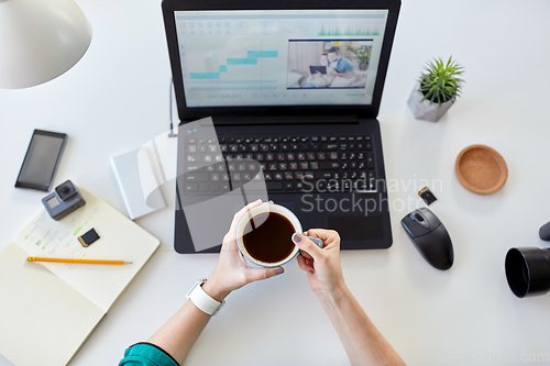 Image of woman with video editor program on laptop at home