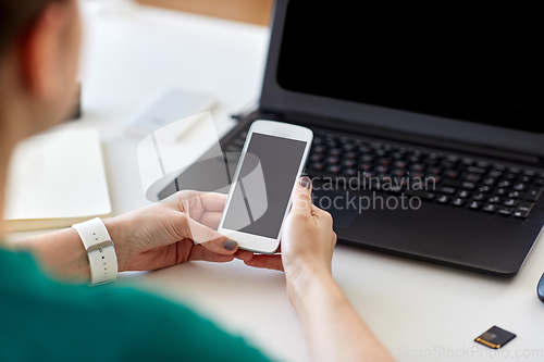 Image of woman smartphone and laptop working at home