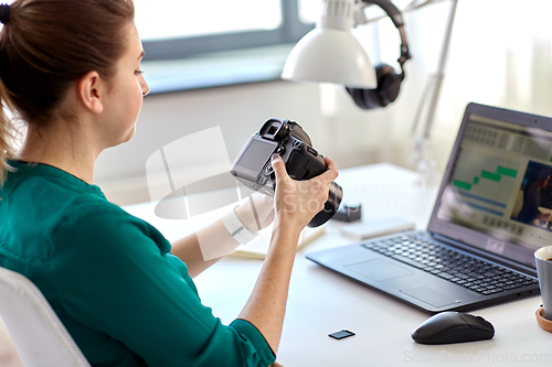 Image of woman with camera and video editor on laptop