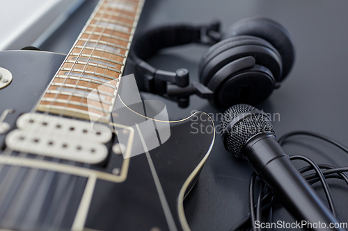 Image of close up of bass guitar, microphone and headphones