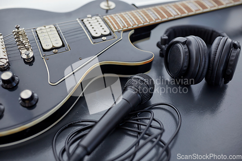 Image of close up of bass guitar, microphone and headphones