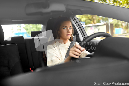 Image of woman or female driver driving car in city