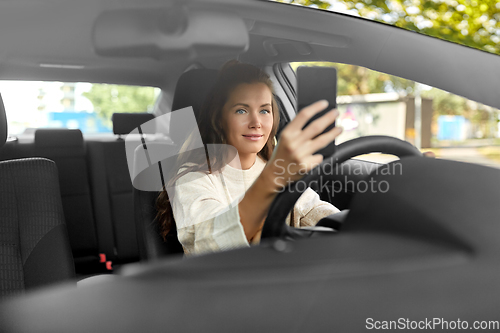 Image of woman or driver driving car and taking selfie