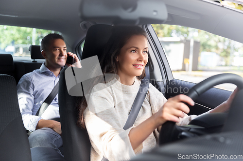 Image of female driver driving car with male passenger