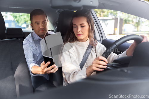 Image of female driver driving car with male passenger