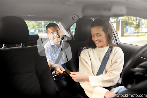 Image of female car driver takes credit card from passenger