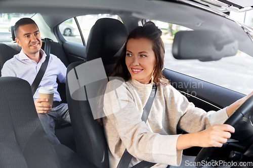 Image of female driver driving car with male passenger