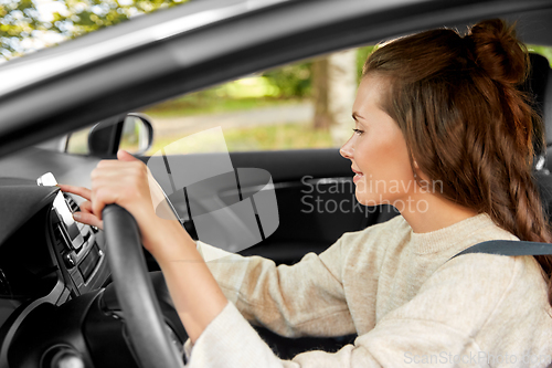 Image of smiling woman or female driver driving car in city