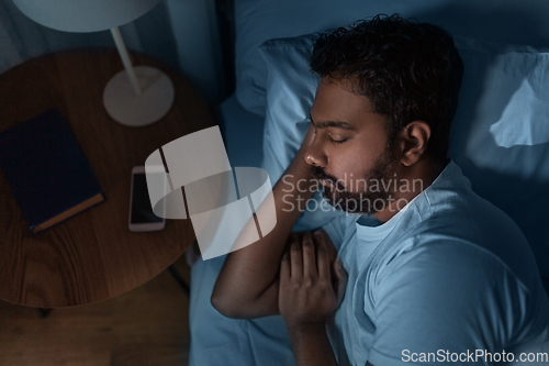 Image of indian man sleeping in bed at home at night