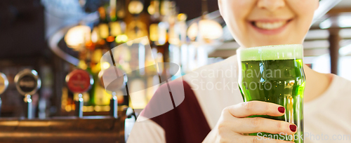 Image of close up of woman with green beer in glass