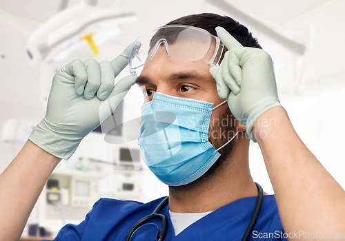 Image of male doctor in goggles, mask and gloves