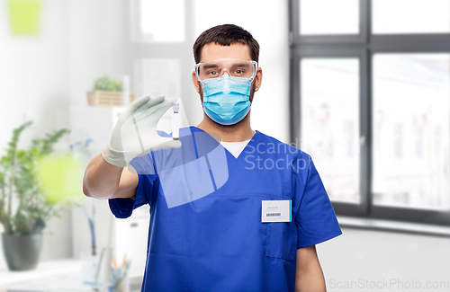 Image of male doctor in mask with blood in test tube