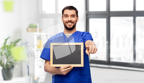 Image of happy smiling male doctor or nurse with chalkboard