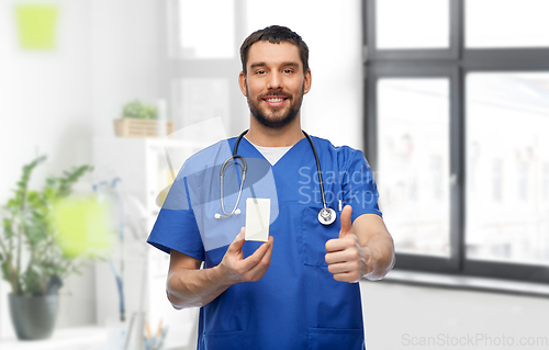 Image of male doctor with medicine showing thumbs up