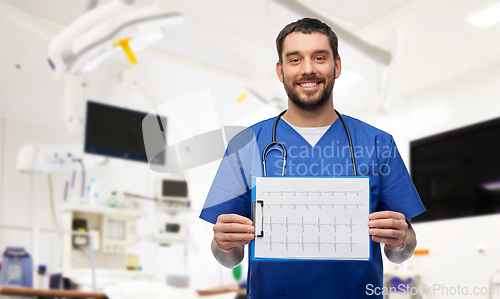 Image of smiling male doctor with cardiogram on clipboard