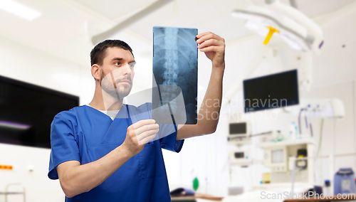 Image of doctor or male nurse looking at x-ray scan