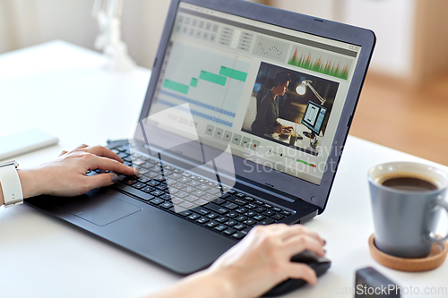 Image of woman with video editor program on laptop at home