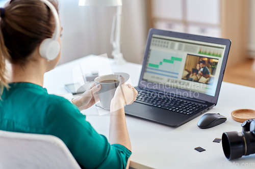 Image of woman with video editor program on laptop at home