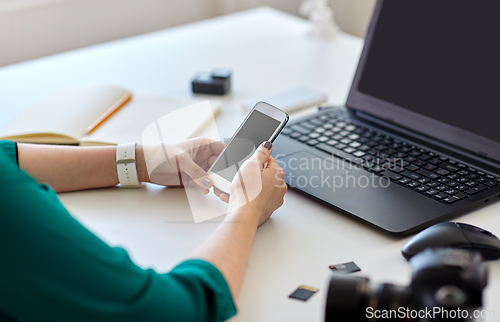 Image of woman smartphone and laptop working at home