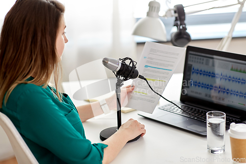 Image of woman with microphone recording podcast at studio