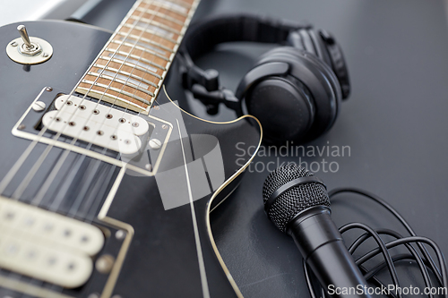 Image of close up of bass guitar, microphone and headphones