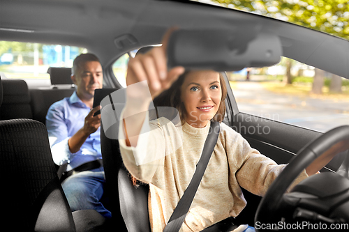 Image of female driver driving car with male passenger