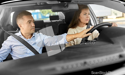 Image of car driving school instructor teaching woman