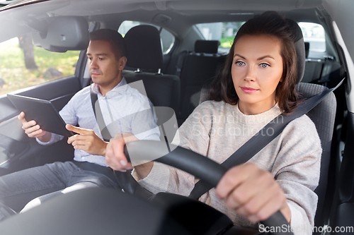 Image of woman and driving school instructor in car