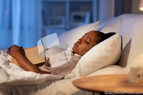 Image of african woman sleeping in bed at home at night