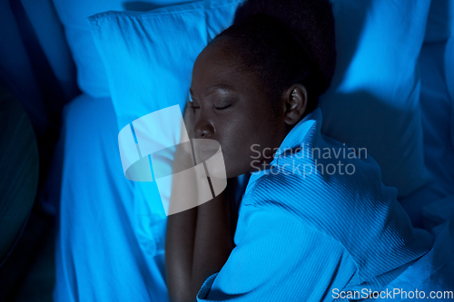 Image of african woman sleeping in bed at home at night