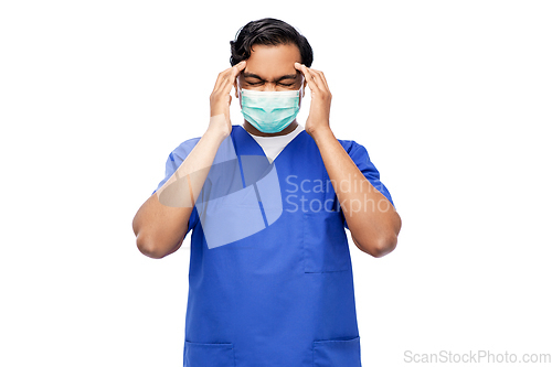 Image of stressed indian doctor in mask having headache