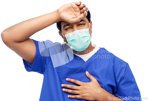 Image of tired indian male doctor in blue uniform and mask