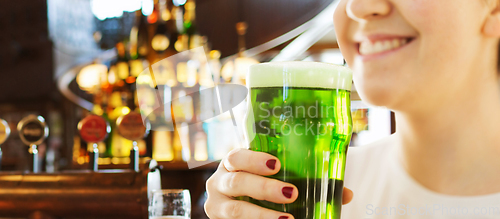 Image of close up of woman with green beer in glass